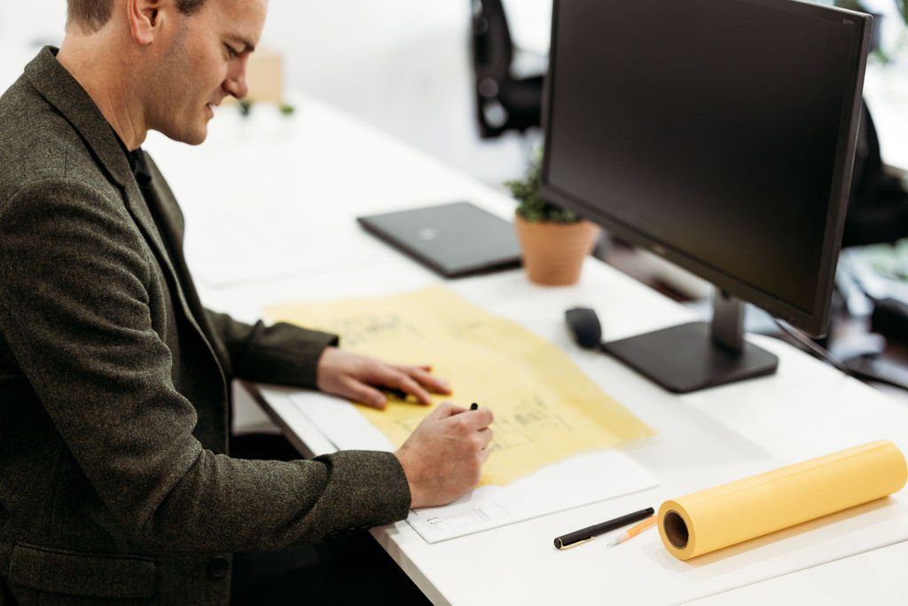 Laszlo sketching a floor plan on trace paper